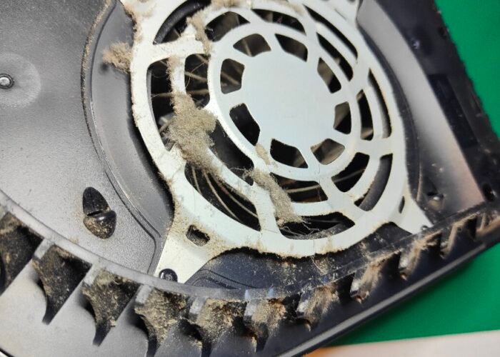 A heavy build-up of dust on the fan intake guide on the underside of this PlayStation 5. The case air grills are clogged too. This was a very dusty, dirty machine.