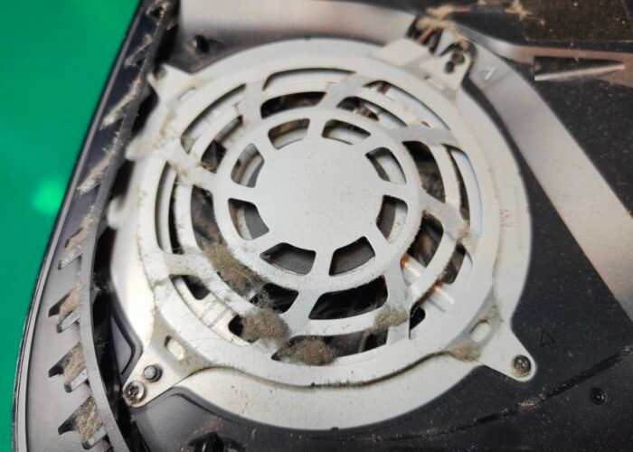 Thick dust on the fan intake guide at the top of this PlayStation 5. We remove this guide to get access to the cooling fan.