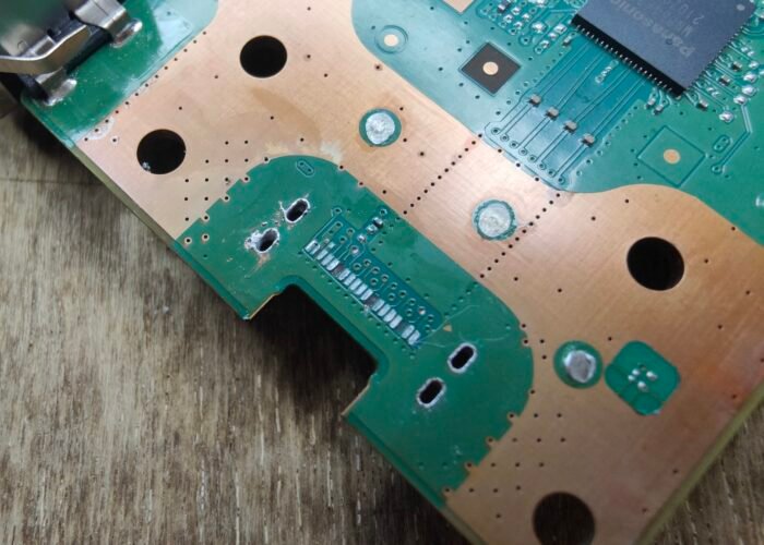 This close-up shows the torn-off connector pads on the damaged PS5 motherboard, where the HDMI socket used to sit.