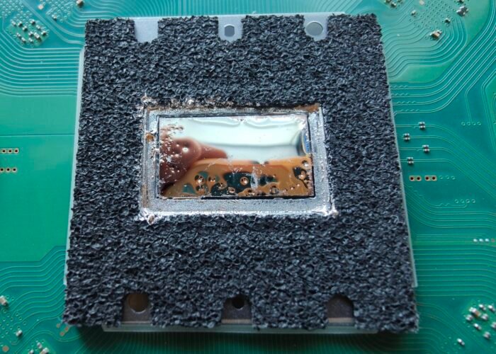 Freshly refreshed liquid metal on a PlayStation 5 APU. There was slightly too much on here, so we removed some before closing the machine up. After testing, this Sheffield repair ran cooler and much quieter than before.